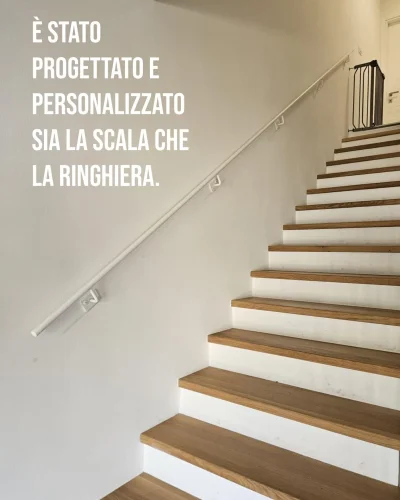 Scala interna con gradini in legno e ringhiera in ferro bianco